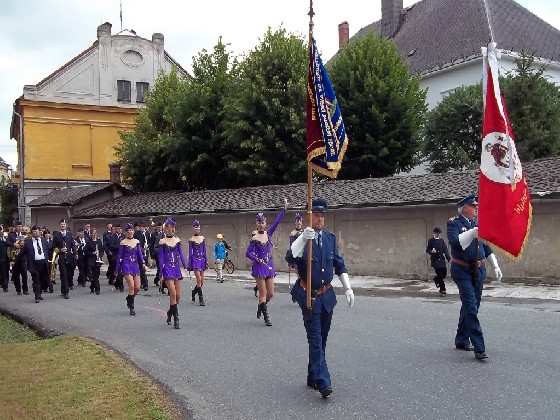 Slavnostní průvod s prapory, hudbou a mažoretkami se blíží ke sportovnímu areálu T.J. Vidnava  foto (MAr).JPG